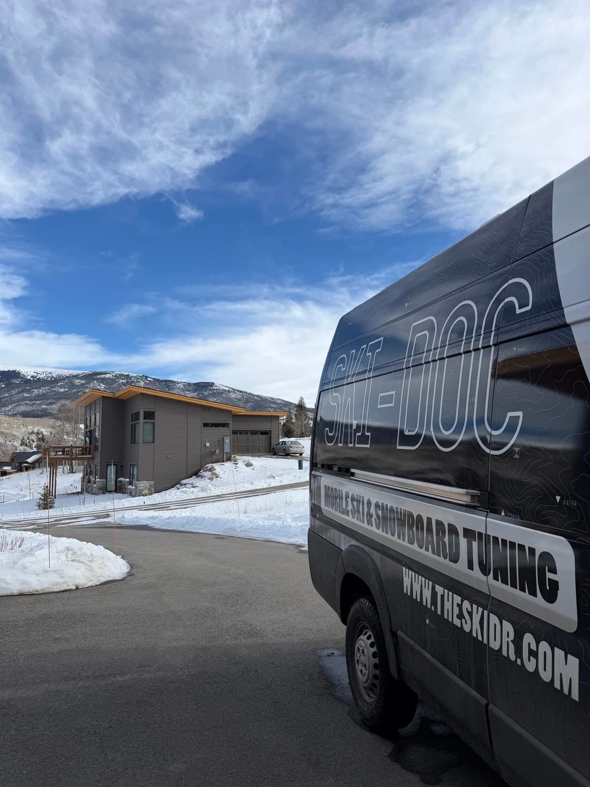 Slope Ready tuning van parked with snowy Colorado mountains behind