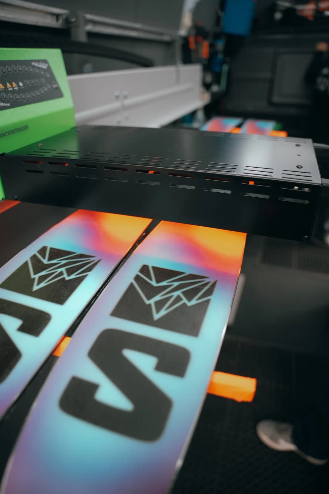 Skis moving through a professional waxing machine